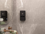 Black ONNYBODY body wash, shampoo and conditioner dispenser mounted on a marble bathroom wall