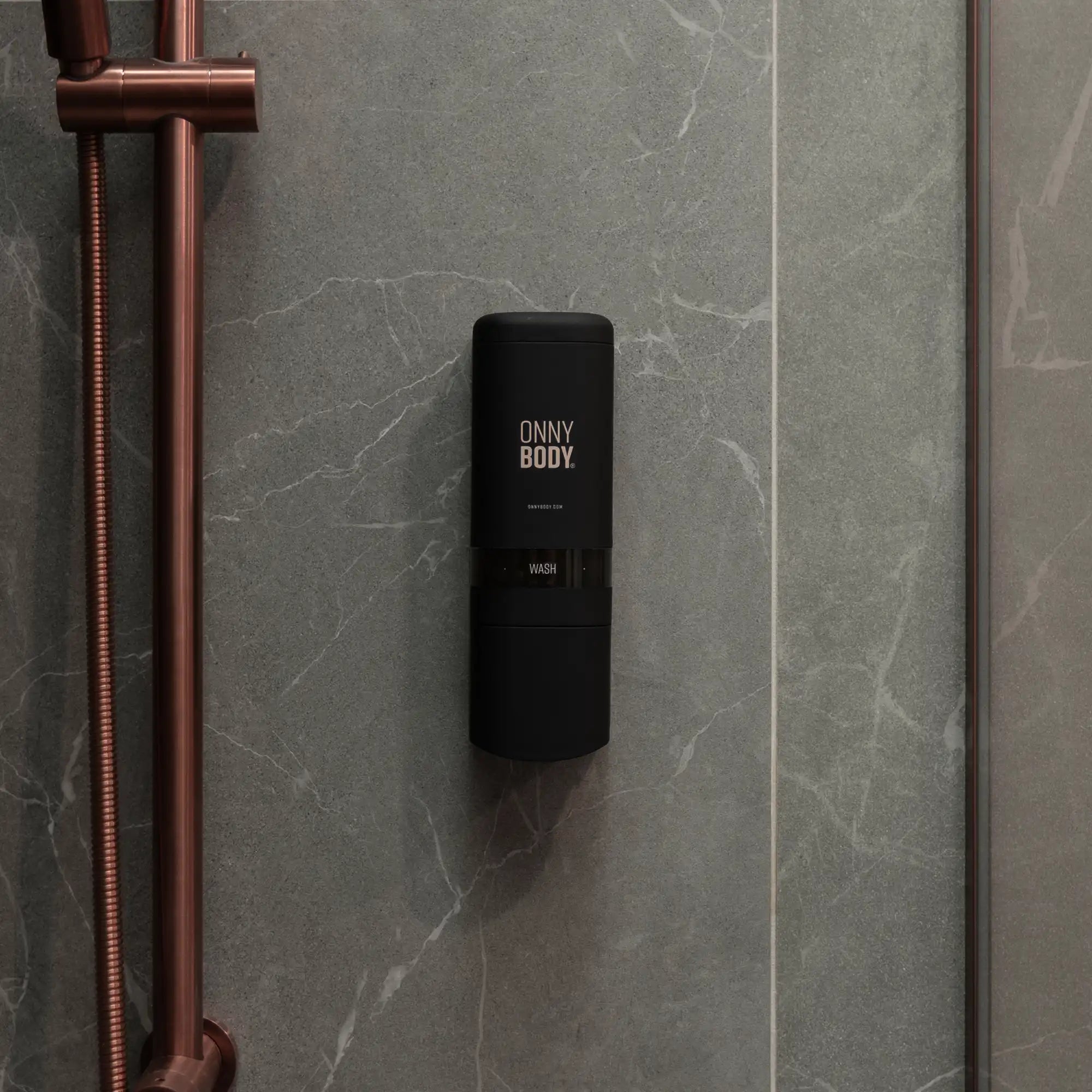 one black ONNYBODY dispenser attached to a tiled bathroom wall.