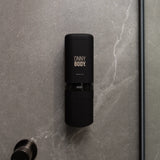 one black ONNYBODY dispenser attached to a tiled bathroom wall.