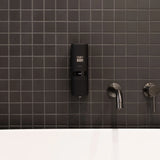 Black ONNYBODY dispenser mounted on a dark tiled wall with silver faucet.